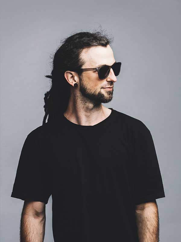 young-man-in-sunglasses-and-black-t-shirt-on-a-gre-AD5THCE.jpg